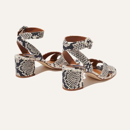 The City Sandal - Natural Python Embossed by margaux-development features open toes, block heels, ankle straps with buckle closures, a cushioned insole for comfort, and a black-and-white snakeskin pattern. Displayed on a light background.