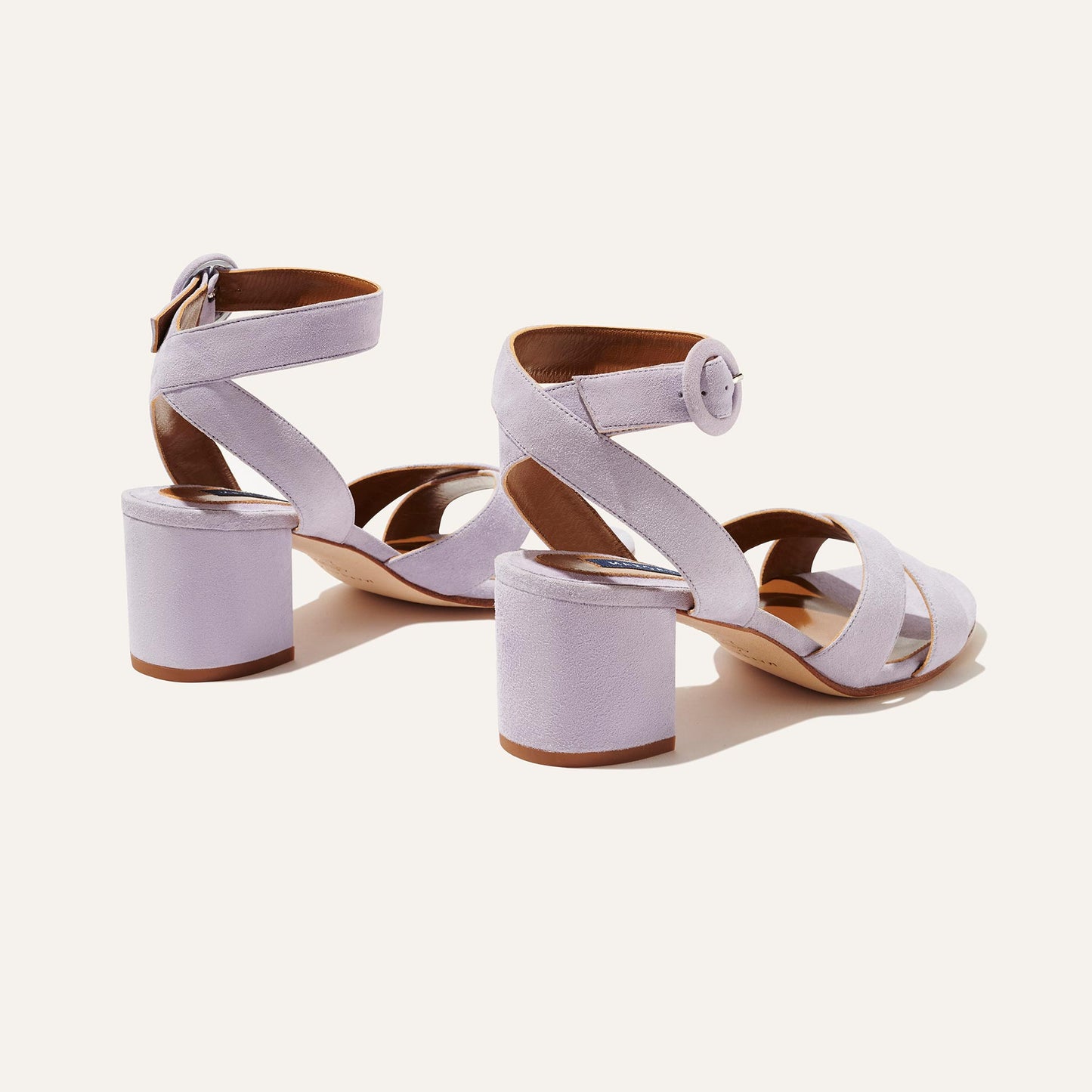 The City Sandal - Lilac Suede by margaux-development features light purple suede, thick block heels, crisscross and ankle straps with round buckles, and a cushioned insole for comfort, shown on a neutral background.