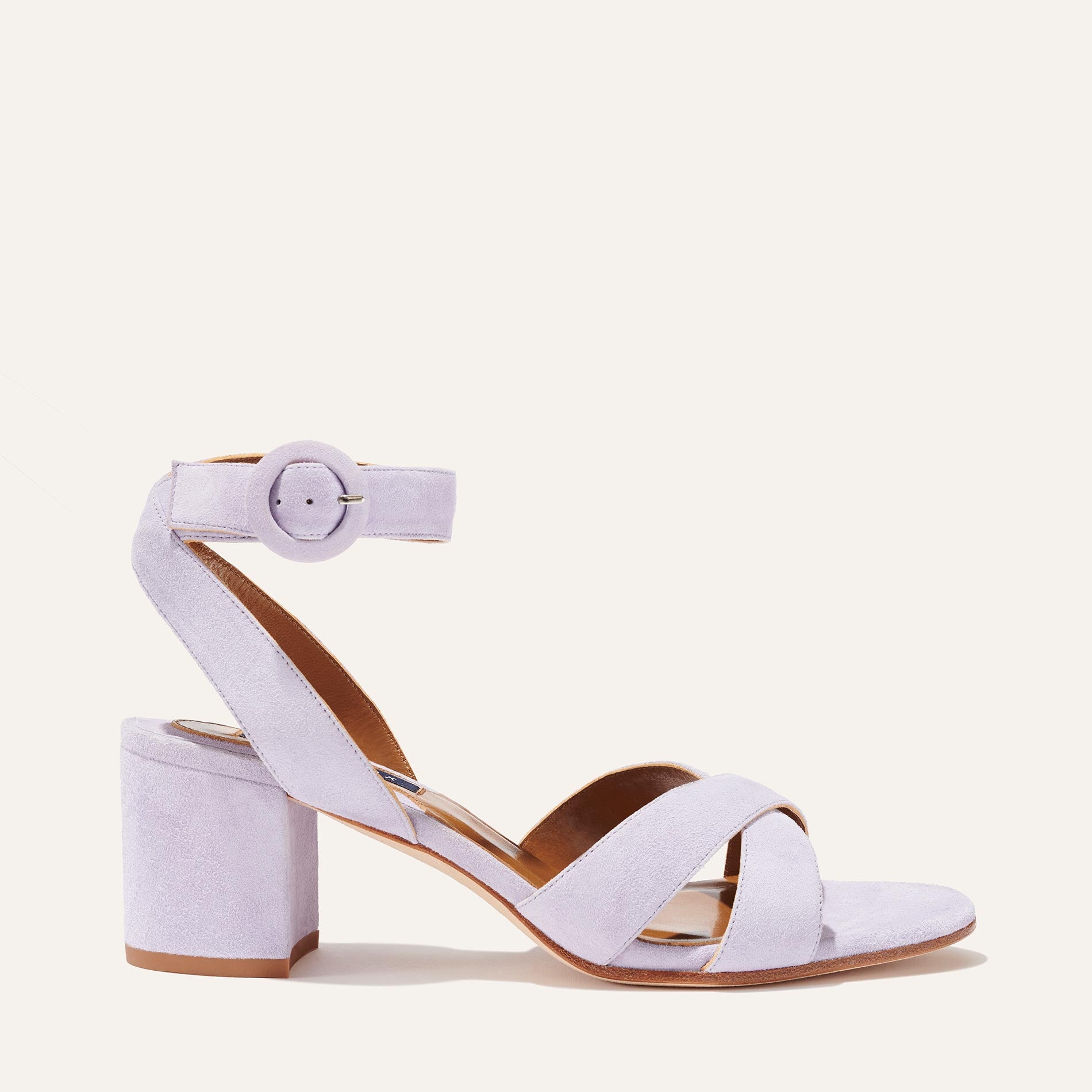 The City Sandal - Lilac Suede by margaux-development features crisscross toe straps, an ankle strap with a round buckle, a thick block heel, and cushioned insole for comfort, all in light purple suede and displayed on a plain background.