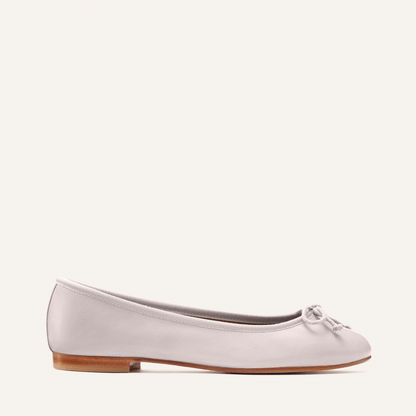The Demi - Dove Nappa by margaux-development is a handmade light gray ballet flat from Spain, featuring a small front bow, low wooden heel, and classic design, shown against a plain off-white background.