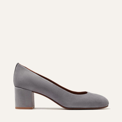 The Heel - Steel Suede by Margaux: a gray suede women's pump with a rounded toe and elegant block heel, shown in side profile against a plain light background.
