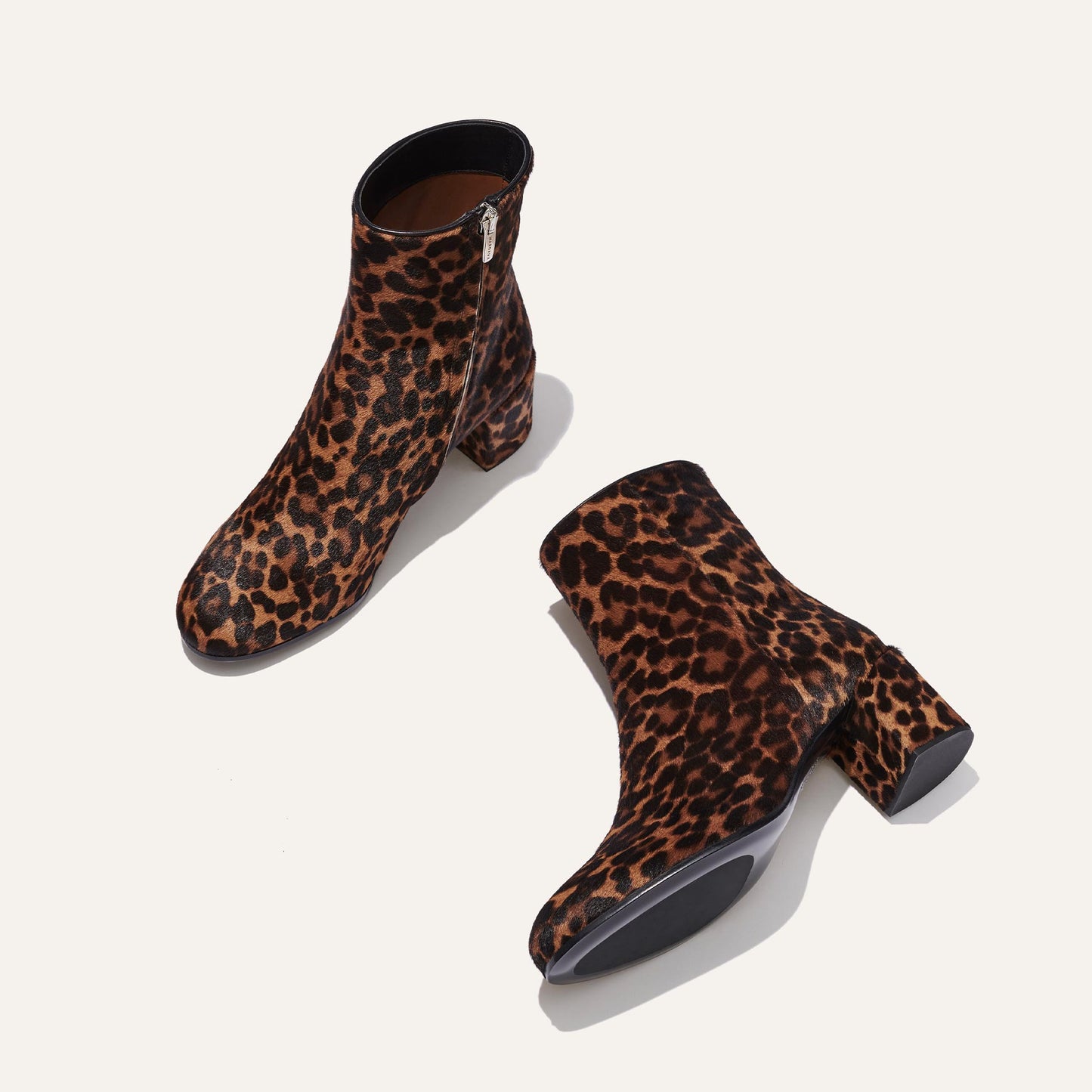 The Boot - Chocolate Leopard Haircalf by Margaux: elegant ankle boots with a chunky heel, almond toe, bold leopard print, and side zippers, shown on a light background.
