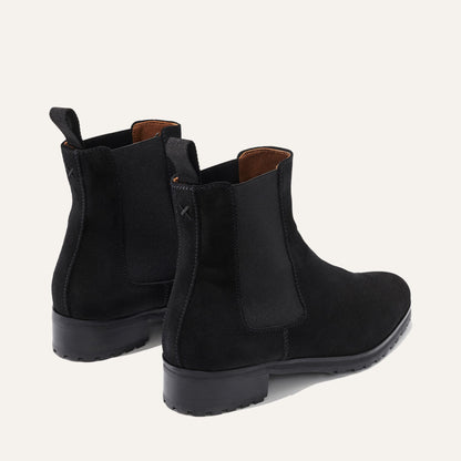 The Chelsea Boot - Black Suede by Margaux, featuring elastic side panels and pull tabs, shown from the back and side on a light background.