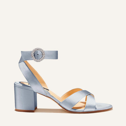 The City Sandal by margaux-development features powder satin, a crystal-embellished buckle, crisscross toe straps, an ankle strap, cushioned insole, and a mid-height block heel for comfort.