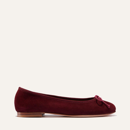 The Demi - Mulberry Suede by margaux-development is a bestselling ballet flat handmade in Spain, crafted from burgundy suede with a small bow, low wooden heel, and almond toe for exceptional comfort.
