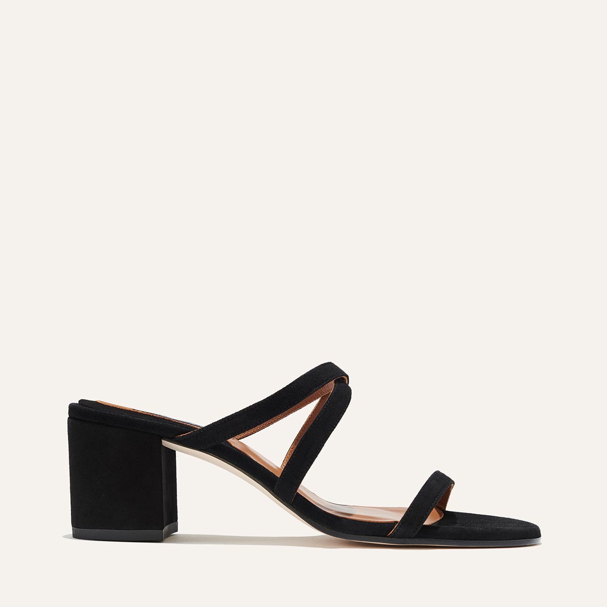 The Perry Sandal - Black Suede by margaux-development features a chunky block heel, two slim straps, and a suede upper. Handmade in Spain, it’s shown against a plain light background.