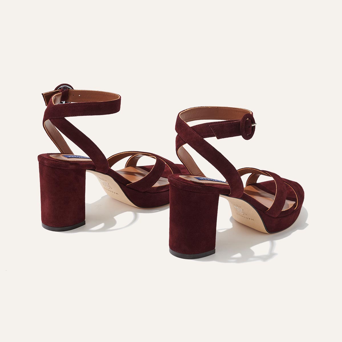 The Platform Sandal - Bordeaux Suede by margaux-development features dark red suede, thick block heels, ankle straps, and open toes for comfort and height. Displayed from back and side angles on a neutral background.