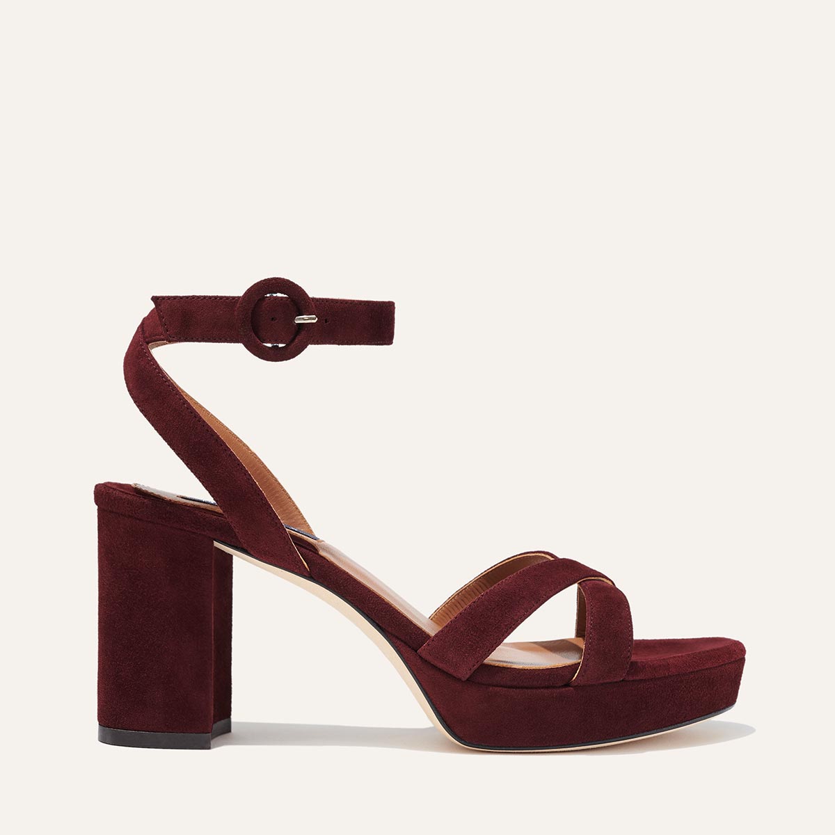 The Platform Sandal - Bordeaux Suede by margaux-development features a chunky block heel, thick platform sole, and ankle strap with round buckle. Two toe straps ensure comfort and style, all set against a plain light background.
