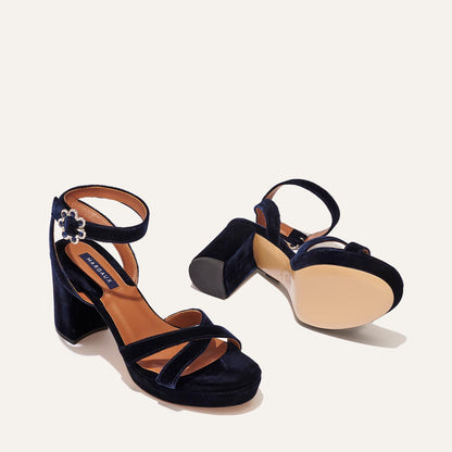 The Platform Sandal - Midnight Blue Velvet by margaux-development: a pair of dark blue velvet platform sandals with ankle straps and block heels. One is upright showing the top, while the other is on its side showing the sole.