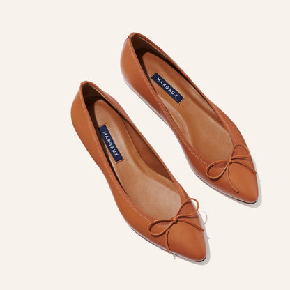 The Pointe in Saddle Nappa, a classic and comfortable ballet flat featuring a refined pointed toe design and decorative bow. 