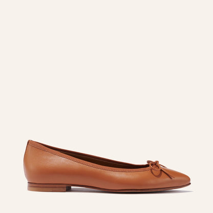 The Pointe in Saddle Nappa, a classic and comfortable ballet flat featuring a refined pointed toe design and decorative bow. 