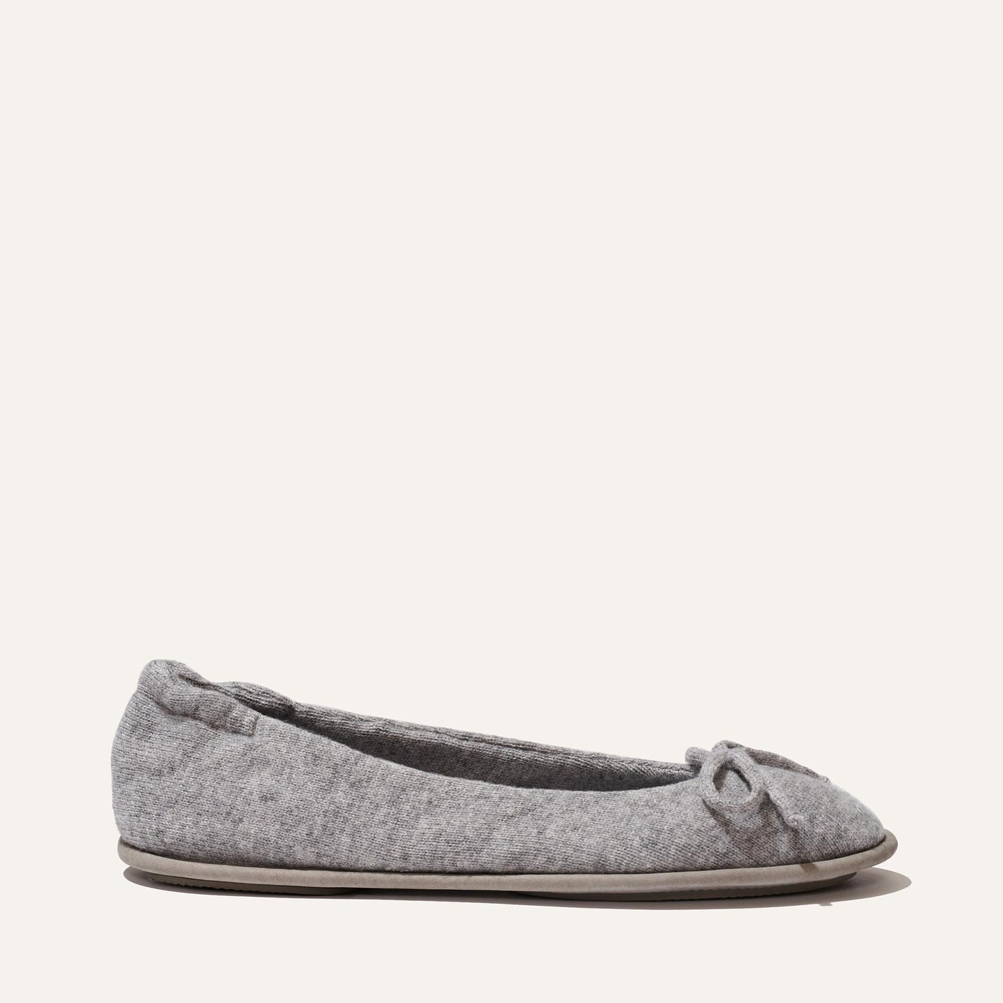 The Slipper - Heather by Margaux is a grey ballet flat with a small bow and plush quilted innersole for comfort, shown on a light background.