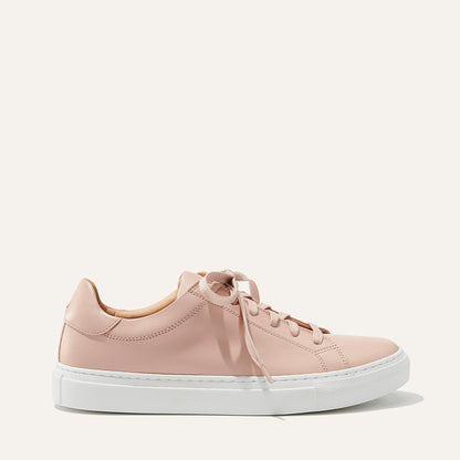 The Sneaker - Rose Calf by margaux-development is a light pink low-top with matching laces and a thick white sole, shown in profile against a plain, light background.