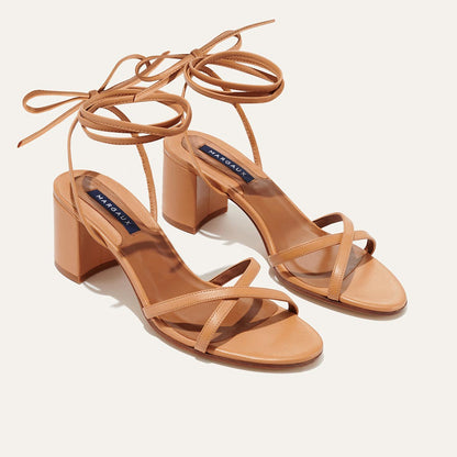 The Soho Sandal in Desert Nappa, featuring thin, flattering straps with a delicate ankle wrap, and a comfortable 2.5-inch block heel.