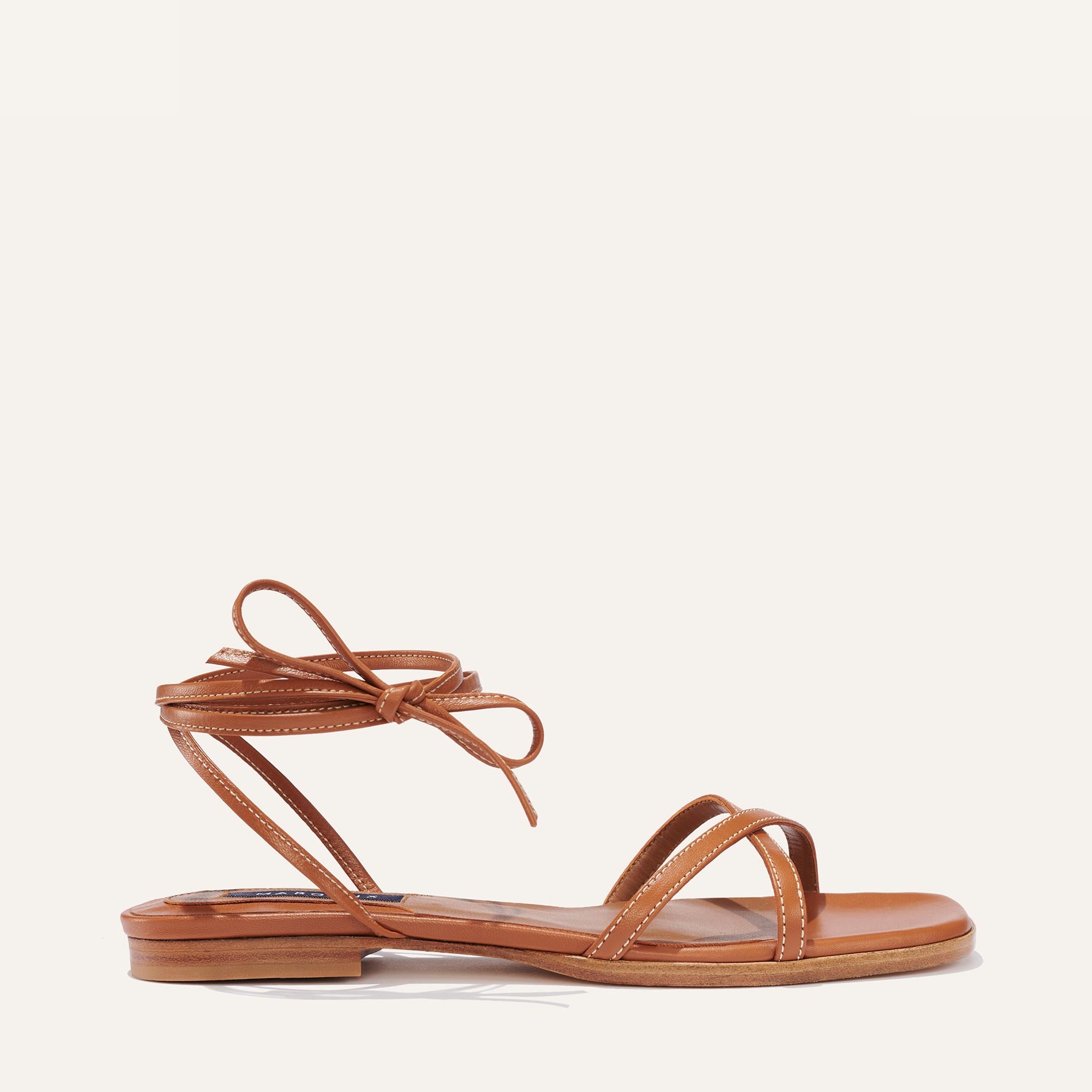 Margaux's classic strappy Wrap Sandal with ankle ties, made in Spain from soft, saddle brown Italian nappa leather